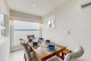 a dining room with a table and chairs and a window at Breezy Point Retreat in Saratoga Shores