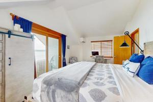 a bedroom with a large bed and a sliding glass door at Breezy Point Retreat in Saratoga Shores