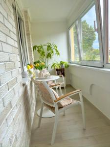 a table and chair in a room with a window at Apartman KATY - self check-in, besplatan parking, blizu centra in Vukovar