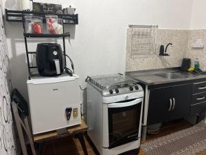 a small kitchen with a stove and a sink at Loft aconchegante - Centro Niterói in Niterói