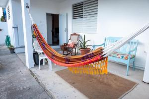 a hammock sitting outside of a house at Cozy West Coast Studio in Cabo Rojo
