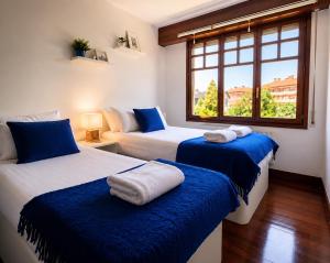 two beds in a room with a window at Chalet Bilbao-Aeropuerto in Sondika