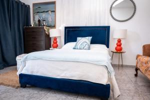 a bed with a blue headboard in a bedroom at Cozy West Coast Studio in Cabo Rojo