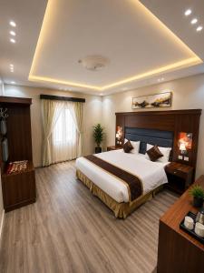 a hotel room with a large bed and a window at ليالي أكنان للشقق المخدومة فرع2 in Abha