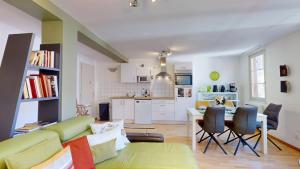 a living room with a green couch and a kitchen at COLMARAPPART Grand'Rue in Colmar