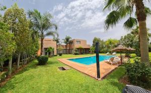 a backyard with a swimming pool and a house at Villa Serenity MARRAKECH in Oulad Mazoug
