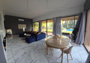 a living room with a blue couch and a table at Villa Serenity MARRAKECH in Oulad Mazoug