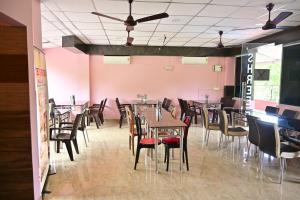 a dining room with tables and chairs and pink walls at HOTEL SHREESH (NEIL) in Neil Island