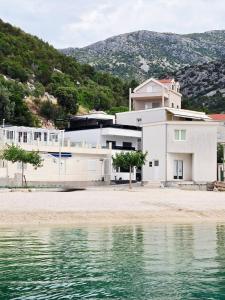 a white house next to a body of water at Villa Truman Klek in Klek