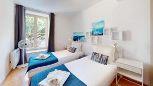 a bedroom with two beds and a window at COLMARAPPART Grand'Rue in Colmar