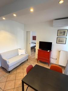 a living room with a couch and a tv and a table at Apartments Rombon in Bovec