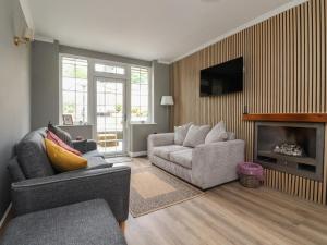a living room with a couch and a chair and a television at Shepherd's Lodge in Skipton