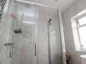 a shower with a glass door in a bathroom at Shepherd's Lodge in Skipton +11 photos