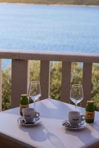 a table with two cups and two glasses on a balcony at Villa Ancora in Neum