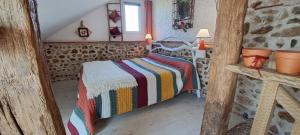 a bedroom with a bed with a colorful blanket at Gîte L'air De Vacances in Bonnée