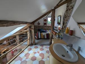 a bathroom with a sink and a bed in a room at Gîte L'air De Vacances in Bonnée +3 photos