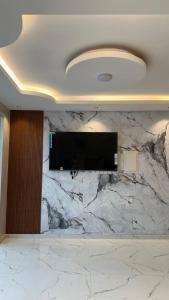 a large marble wall with a flat screen tv on it at Reef Sinaw Apartments in Sinaw