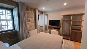 a room with a table and a tv in a room at Caza de Cima de Villa in Penafiel