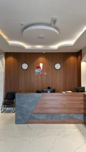 a lobby with clocks on the wall and a desk at Reef Sinaw Apartments in Sinaw