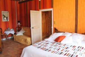 a bedroom with a bed and a couch in it at Chbres D'hôtes Ferme De Champliveau in Bonnée