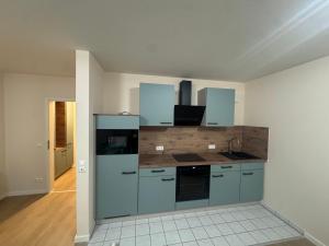 an empty kitchen with blue cabinets in a room at Stay Zentral Dresden in Dresden
