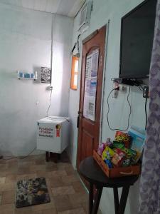 a room with a door and a table with a television at Hospedagem Chapéu Virado in Belém +4 photos