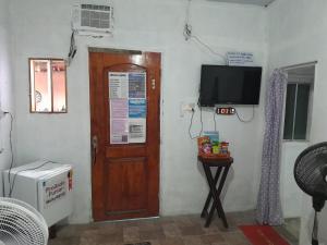 a room with a door and a television on a wall at Hospedagem Chapéu Virado in Belém