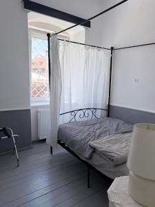 a bedroom with a canopy bed with a window at Sowa Loft in Zagórze Śląskie