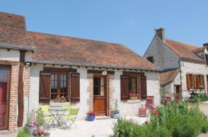 an old brick house with a patio and chairs at Chbres D'hôtes Ferme De Champliveau in Bonnée