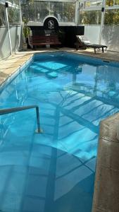 a large blue swimming pool with a bench in the background at Apart Hotel Punta Vip in Colón