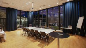 a conference room with a white table and chairs at Lindesnes Havhotel in Spangereid