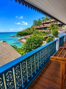 a balcony with a bench and a view of the ocean at Nami by Secret Place in Mae Haad