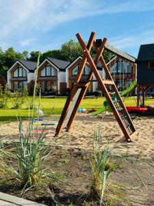 a playground with a wooden play structure in a yard at Morze Na Zawsze in Rewal