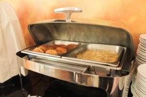a pan filled with food on top of a stove at Hotel Leonardo da Vinci in Santiago