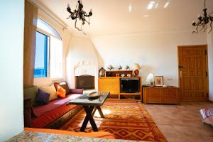 a living room with a couch and a tv at Get Salty Guesthouse in Tamraght Ouzdar