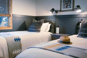 a room with two beds with a hat on them at Pinedale Cozy Cabins in Pinedale