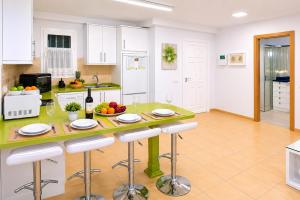 a kitchen with a table with a bowl of fruit at GOLDEN BEACH MOGAN in Puerto de Mogán