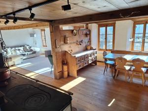 a kitchen and living room with a table and chairs at Rauft-Perfekter Rückzugsort für besondere Feierlichkeiten 2500 m2 Grundstück mitten in der Natur in Hasliberg +32 photos