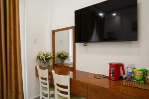 a kitchen with a table with chairs and a television at Dốc Phố Home - Dalat Homestay in Xuan An