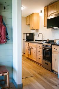 a kitchen with wooden cabinets and a stove top oven at Pinedale Cozy Cabins in Pinedale