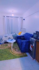 a living room with a blue couch and a table at Urban Haven Homes in Kiambu