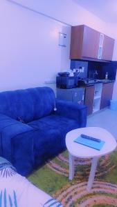 a living room with a blue couch and a table at Urban Haven Homes in Kiambu