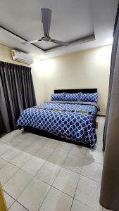 a bedroom with a bed with a blue comforter at Executive Deluxe Studio Apt-Osu in Christiansborg