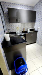 a kitchen with a black counter top and a blue stool at Executive Deluxe Studio Apt-Osu in Christiansborg +1 photo