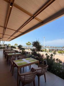 a row of tables and chairs on a patio at Hotel Kamomil in Durrës