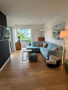 a living room with a blue couch and a table at Premium Penthouse Parkblick in Bad Driburg