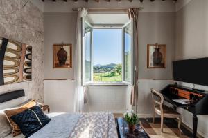 a bedroom with a bed and a window and a desk at Villa Mon Paradis in Lucca