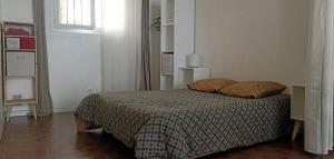 a bedroom with a bed with two pillows on it at Studio privé - maison de village in Valensole
