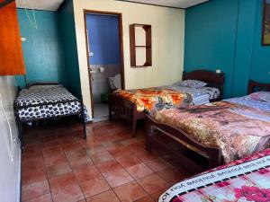 a room with two beds and a bathroom with a toilet at Transilvania in Baños