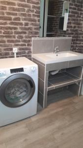 a bathroom with a washing machine and a sink at Maison Conviviale amiens in Amiens